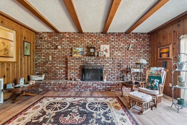 a living room with a rug and a fireplace