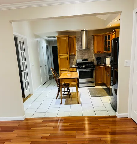 a kitchen with stainless steel appliances kitchen island granite countertop a refrigerator and a stove top oven