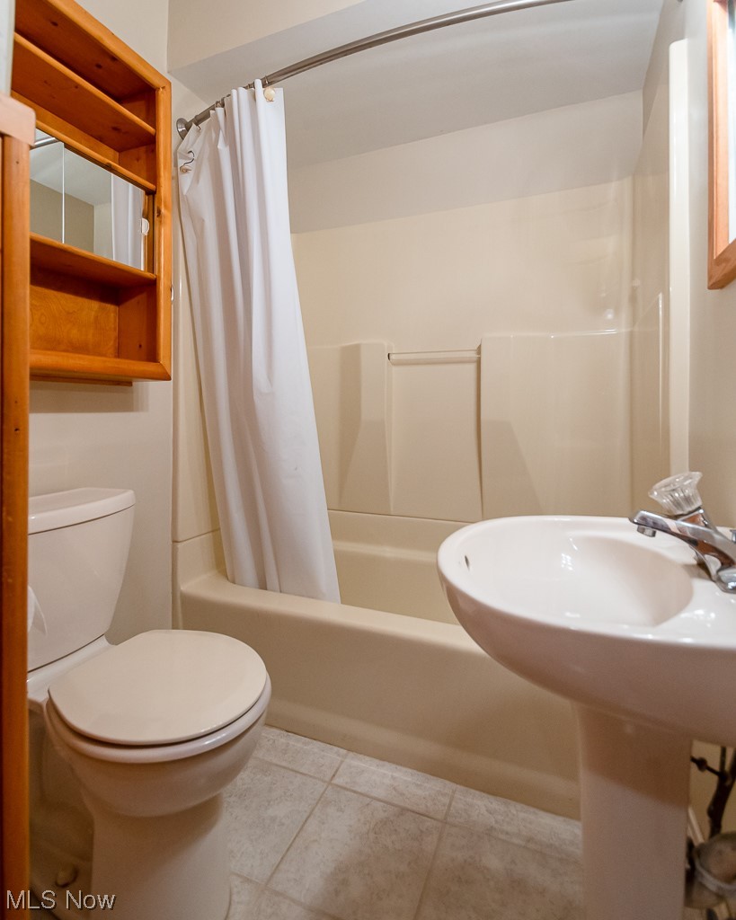 5 Pleasantview Vermilion, OH 44089 - Photo 23 of 37 Full bathroom with shower / bathtub combination with curtain, tile flooring, sink, and toilet