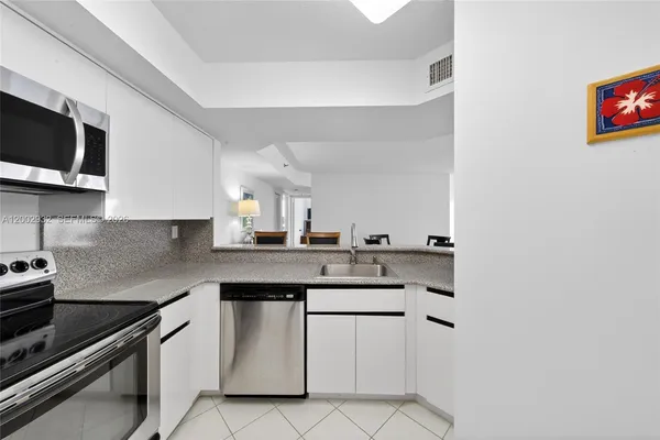 a kitchen with stainless steel appliances granite countertop a sink and a stove
