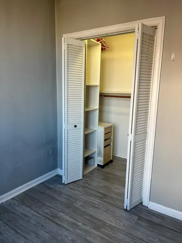 an empty room with wooden floor and a window