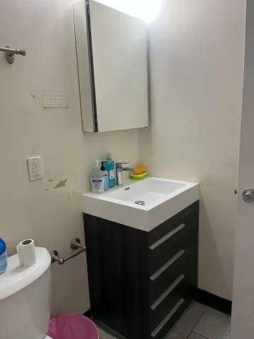 a bathroom with a sink toilet and a mirror