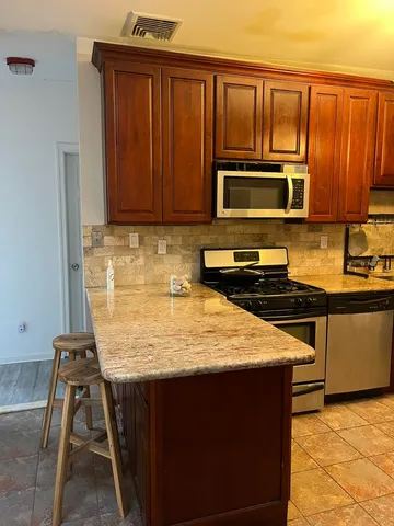 a kitchen with wooden cabinets a microwave oven and a sink with wooden cabinets