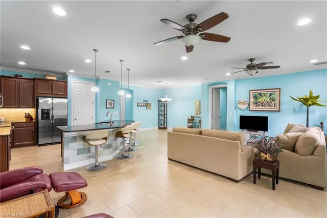 a living room with furniture kitchen view and a chandelier
