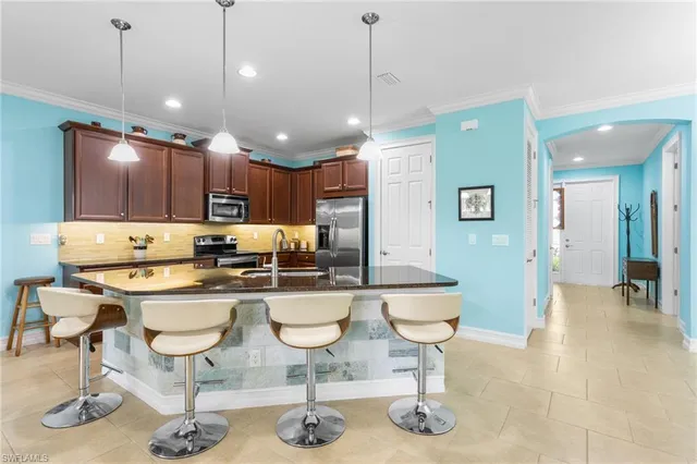 a kitchen with a refrigerator a dining table and chairs