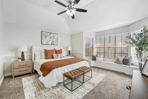 a bed room with a bed couch and a large window