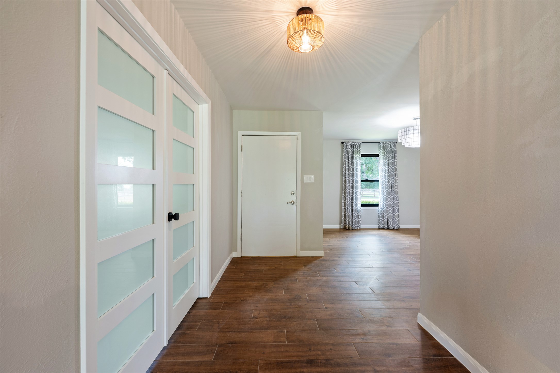 1600 Pin Oak Lane Round Rock, TX 78681 - Photo 4 of 40 Entryway featuring wood-finish flooring, white paneled doors with frosted glass inserts, and a modern ceiling light fixture