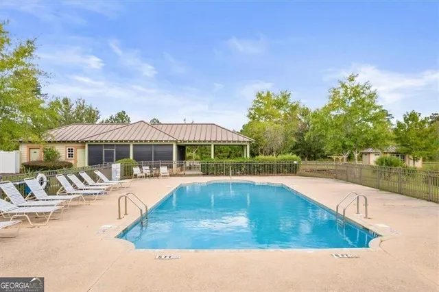a view of a house with pool and chairs