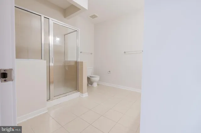 a bathroom with a granite countertop shower and toilet