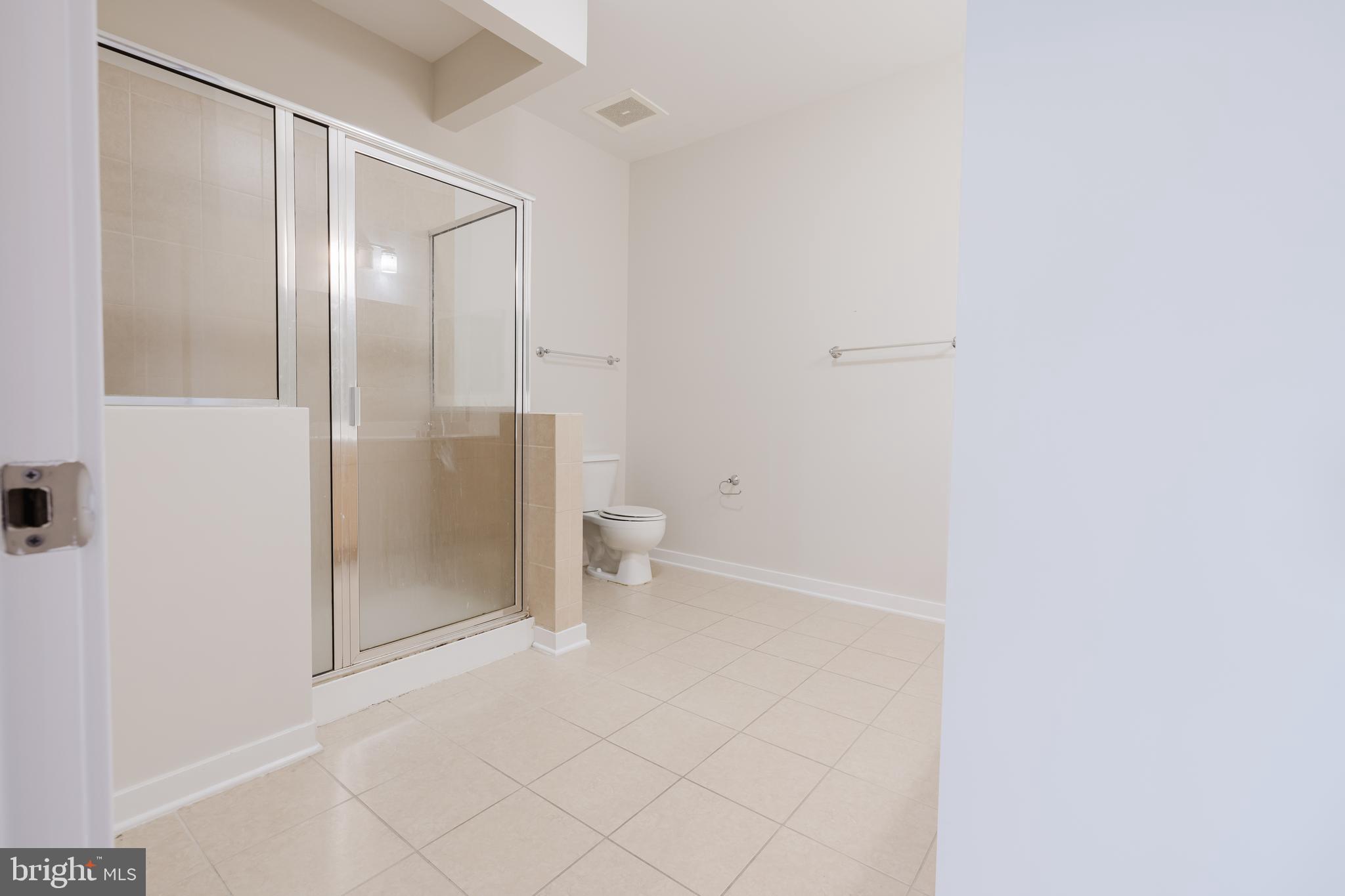 3201 St Paul Street, Unit 412 Baltimore, MD 21218 - Photo 11 of 23 a bathroom with a granite countertop shower and toilet