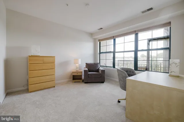 a living room with furniture and a floor to ceiling window