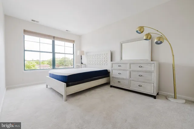 a spacious bedroom with a bed and a window