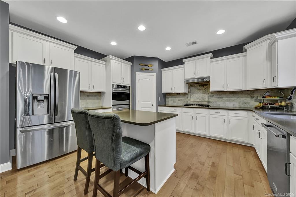 309 Calming Way Tega Cay, SC 29708 - Photo 14 of 41 a kitchen with kitchen island granite countertop wooden cabinets and stainless steel appliances