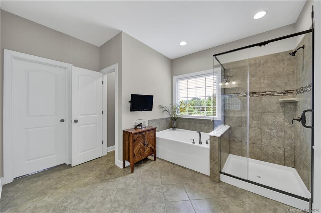 309 Calming Way Tega Cay, SC 29708 - Photo 22 of 41 a bathroom with a tub sink a mirror and a shower