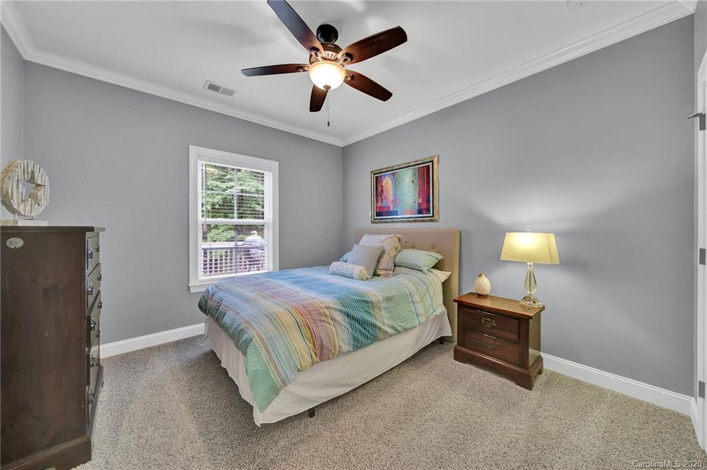 309 Calming Way Tega Cay, SC 29708 - Photo 32 of 41 a bedroom with a bed and a chandelier