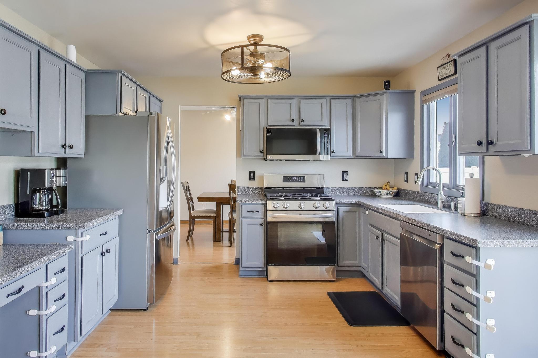 6926 Hawk Drive Schererville, IN 46375 - Photo 12 of 44 a kitchen with stainless steel appliances granite countertop a stove top oven a sink dishwasher a refrigerator and a oven with wooden cabinets