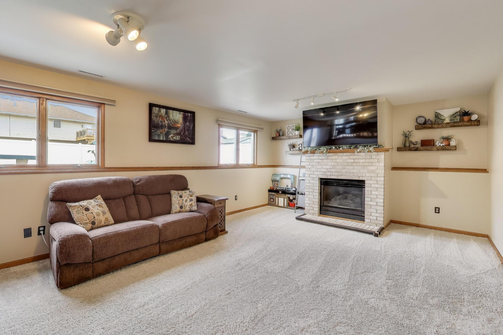 6926 Hawk Drive Schererville, IN 46375 - Photo 26 of 44 a living room with furniture a flat screen tv and a fireplace