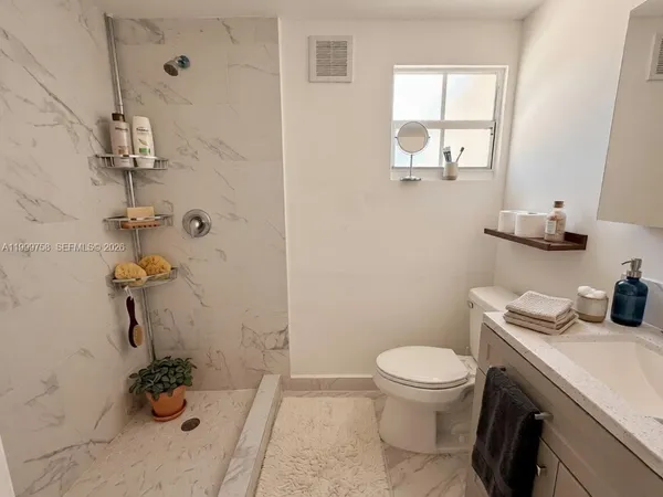 a bathroom with a sink a toilet and shower curtain