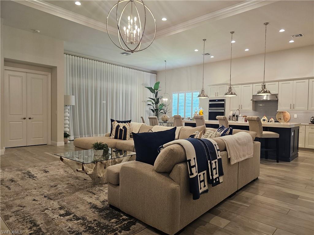 9022 Redonda Drive Naples, FL 34114 - Photo 3 of 28 a living room with furniture kitchen view and a chandelier