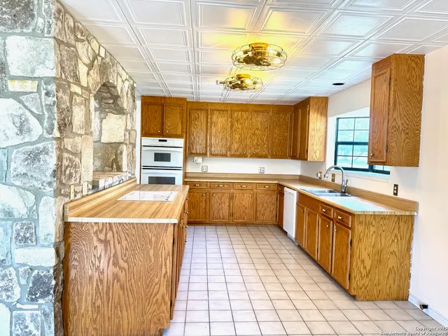 a kitchen with a sink a counter top space and appliances