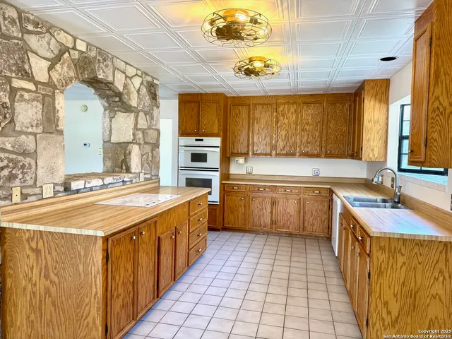a large kitchen with stainless steel appliances granite countertop a sink and cabinets