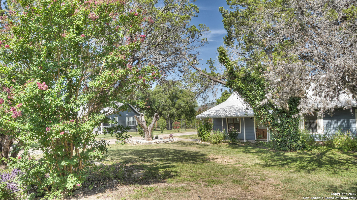 181 Leinweber Drive Leakey, TX 78873 - Photo 4 of 56 a backyard of a house with table and chairs under an umbrella