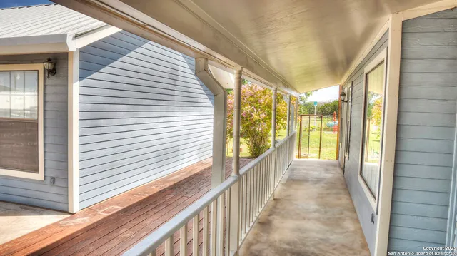 a view of a porch with wooden floor and furniture