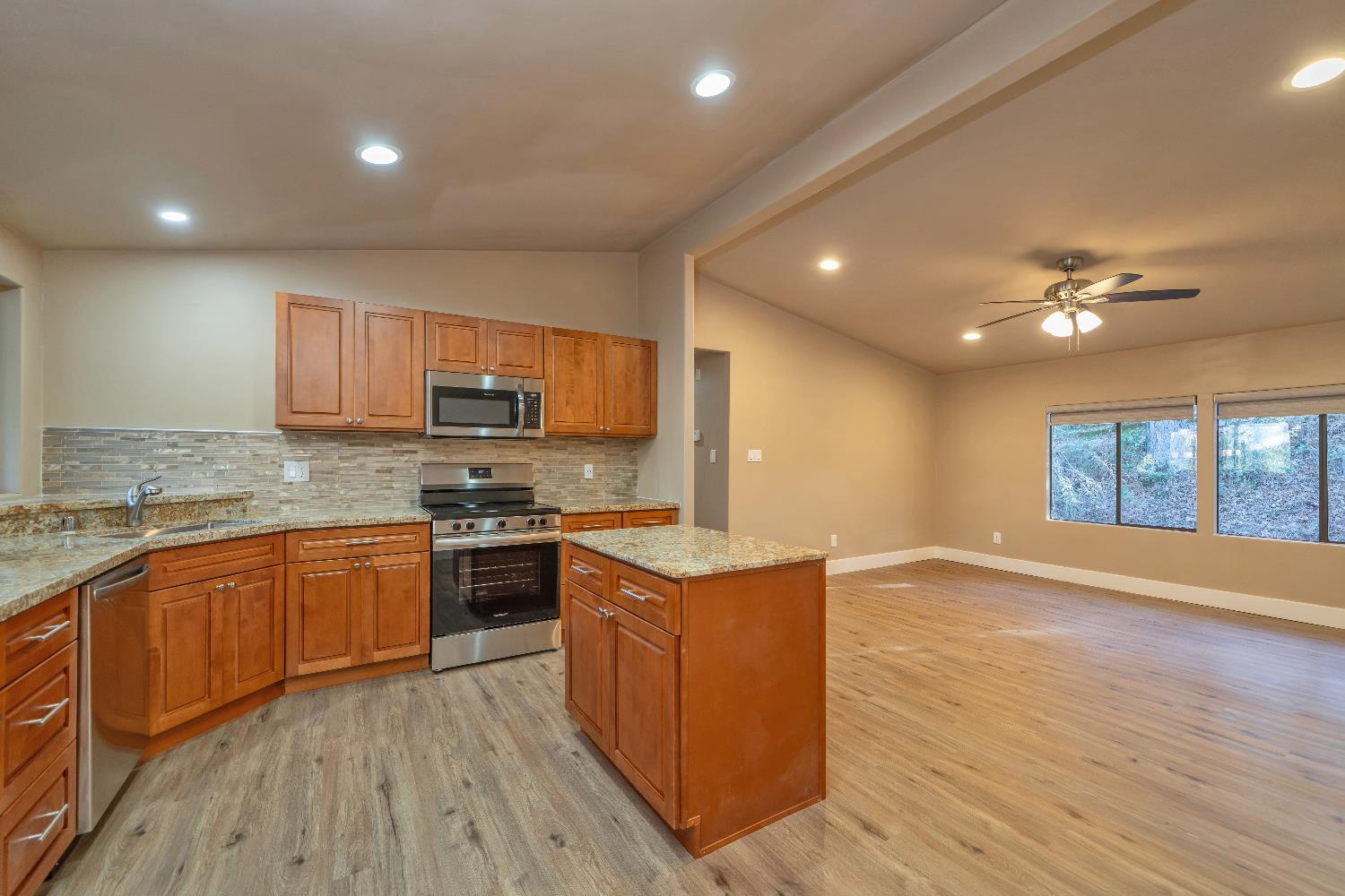 4420 Pleasant Valley Road, Unit 155 Diamond Springs, CA 95619 - Photo 18 of 42 a large kitchen with stainless steel appliances granite countertop a stove top oven a sink dishwasher and wooden cabinets with wooden floor