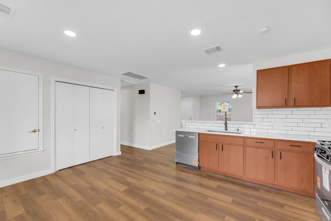11617 Briarcreek Loop Manor, TX 78653 - Photo 10 of 37 Kitchen featuring a peninsula, appliances with stainless steel finishes, tasteful backsplash, recessed lighting, and light wood-type flooring