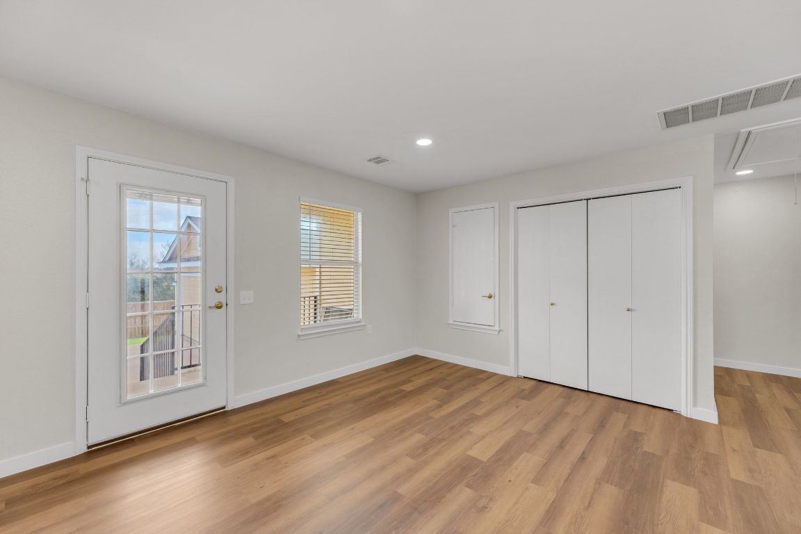 11617 Briarcreek Loop Manor, TX 78653 - Photo 13 of 37 Unfurnished bedroom with attic access, light wood-type flooring, recessed lighting, access to exterior, and a closet