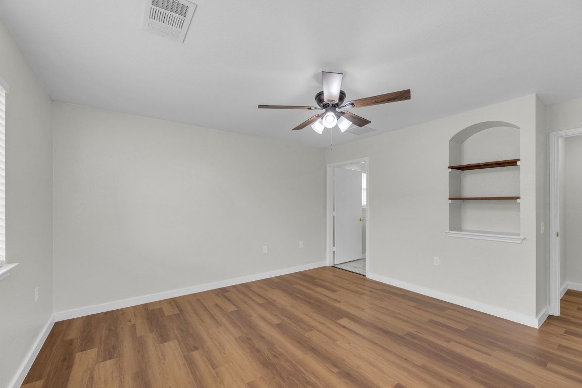 11617 Briarcreek Loop Manor, TX 78653 - Photo 17 of 37 Unfurnished room with built in shelves, wood finished floors, and ceiling fan