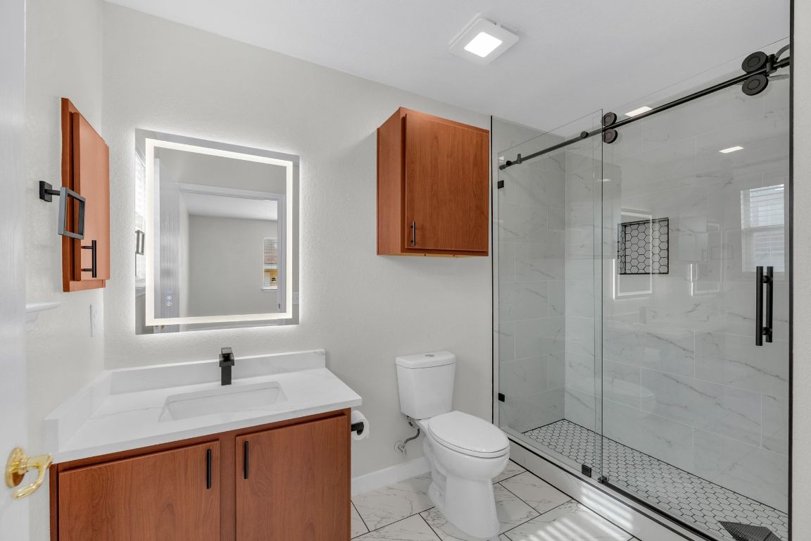 11617 Briarcreek Loop Manor, TX 78653 - Photo 20 of 37 Full bathroom featuring light marble finish floors, a marble finish shower, and vanity