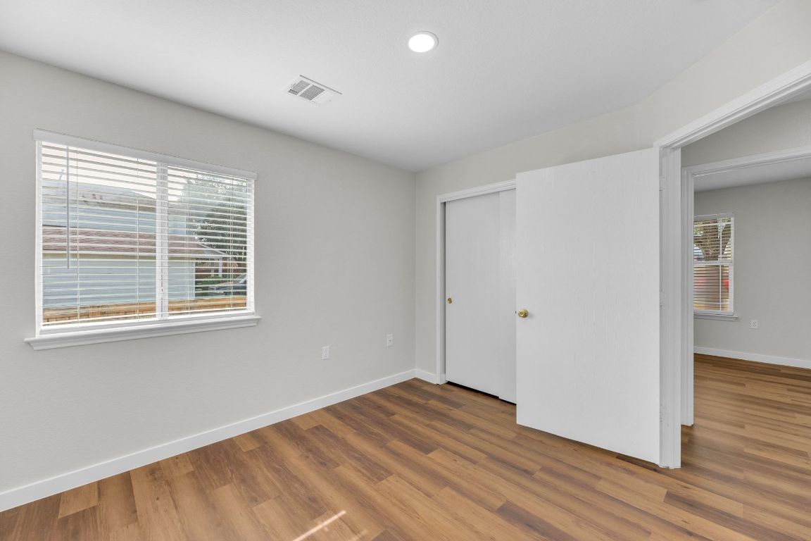 11617 Briarcreek Loop Manor, TX 78653 - Photo 25 of 37 Unfurnished bedroom with wood finished floors, a closet, multiple windows, and recessed lighting