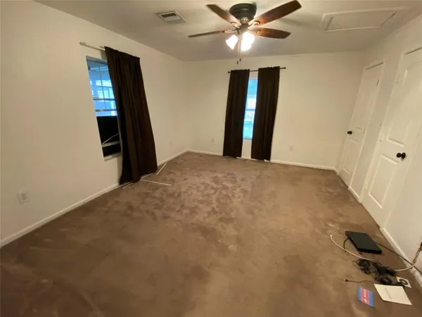 a view of a hallway with wooden floor and closet area