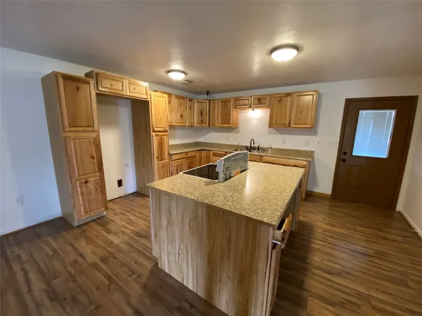 a kitchen with a refrigerator sink and wooden floor