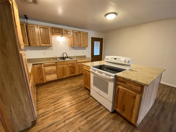 a kitchen with a stove sink and cabinets