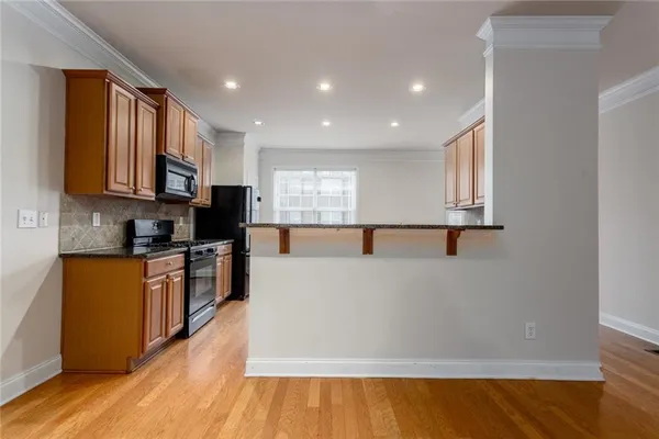 a large kitchen with stainless steel appliances granite countertop a stove a sink and a white cabinets