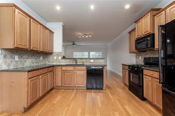 a kitchen with stainless steel appliances granite countertop a stove a sink and a microwave