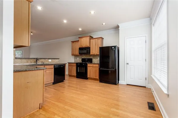 a kitchen with stainless steel appliances granite countertop a refrigerator and a stove