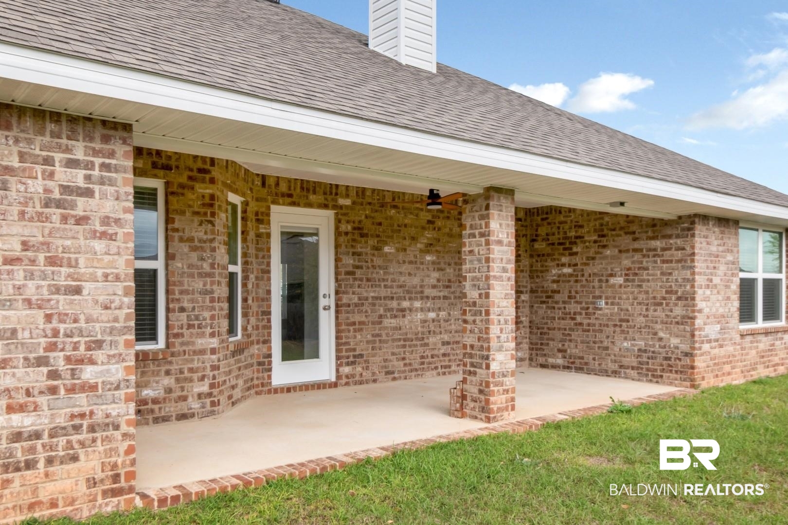 6632 Monarch Circle Mobile, AL 36618 - Photo 26 of 32 Entrance to property featuring brick siding, a chimney, a patio, roof with shingles, and a lawn