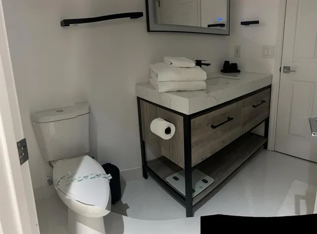 a bathroom with a sink toilet and a mirror