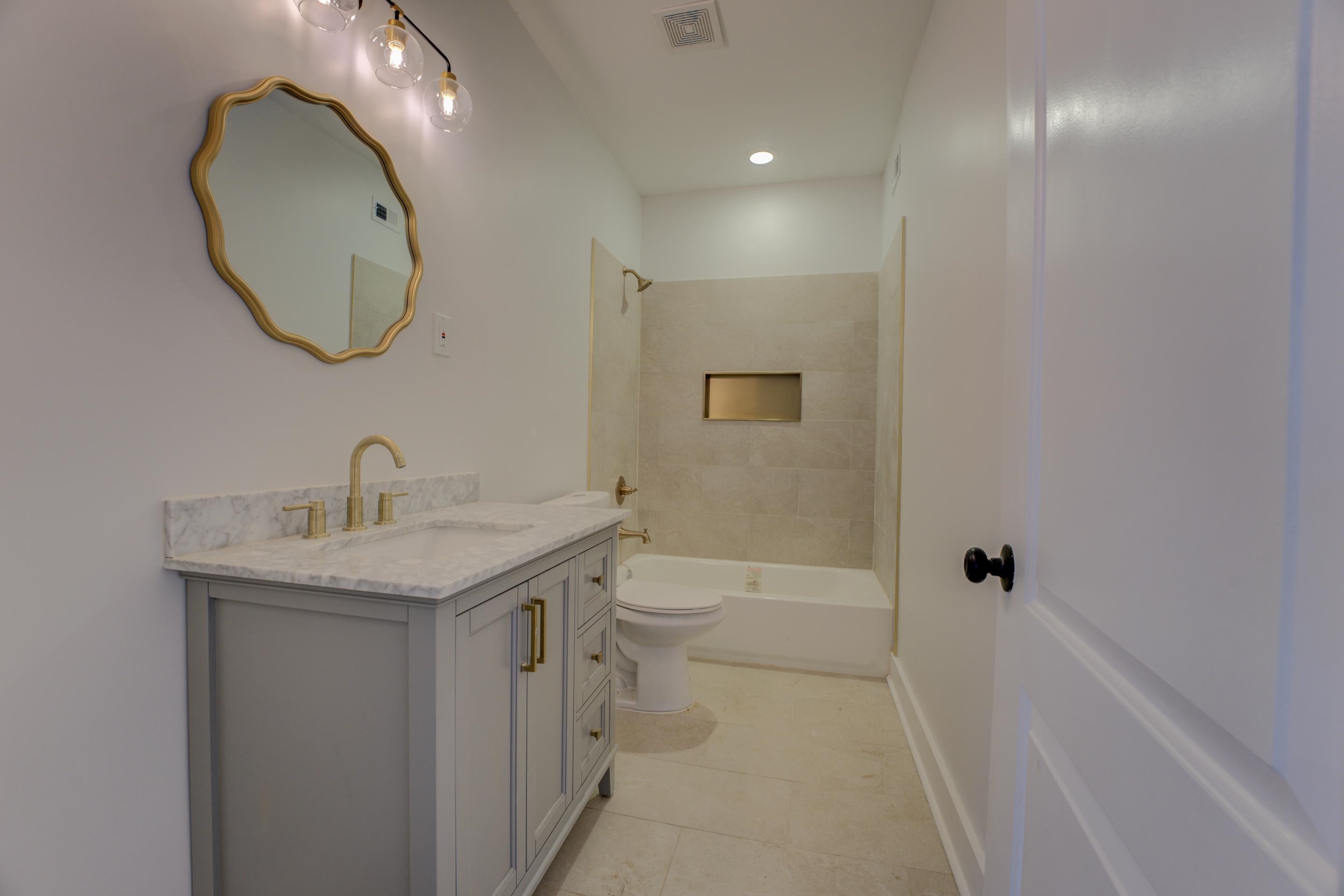 857 E Parkway South Memphis, TN 38104 - Photo 20 of 30 a bathroom with a granite countertop sink a toilet and a mirror