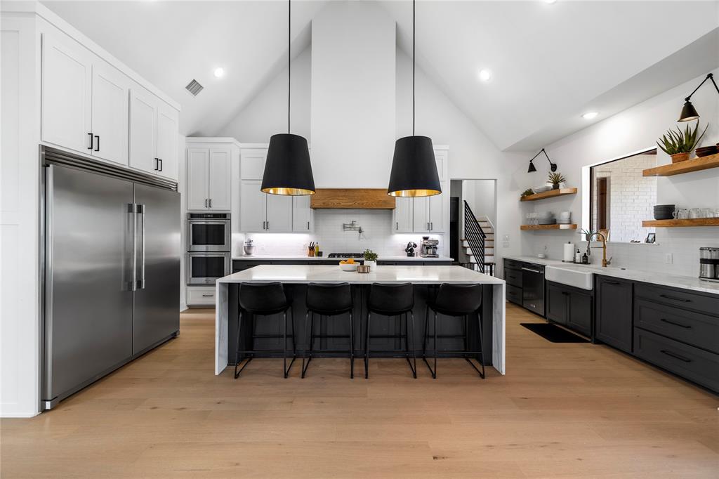 21197 Gatlinburg Road Bullard, TX 75757 - Photo 12 of 40 a kitchen with stainless steel appliances kitchen island granite countertop a table chairs sink and cabinets