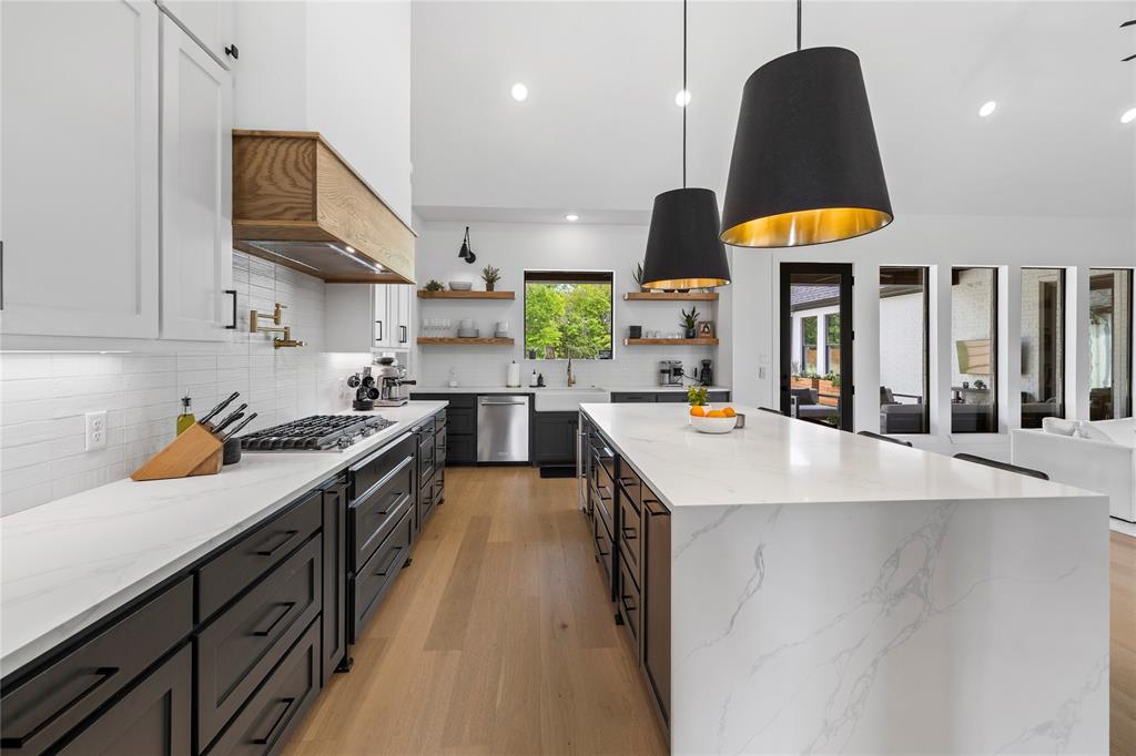 21197 Gatlinburg Road Bullard, TX 75757 - Photo 13 of 40 a kitchen with kitchen island a stove a sink a refrigerator and chairs