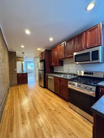 a kitchen with stainless steel appliances granite countertop wooden cabinets a stove top oven a sink and dishwasher