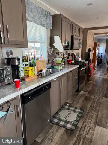 a kitchen with kitchen island granite countertop a sink stove and cabinets
