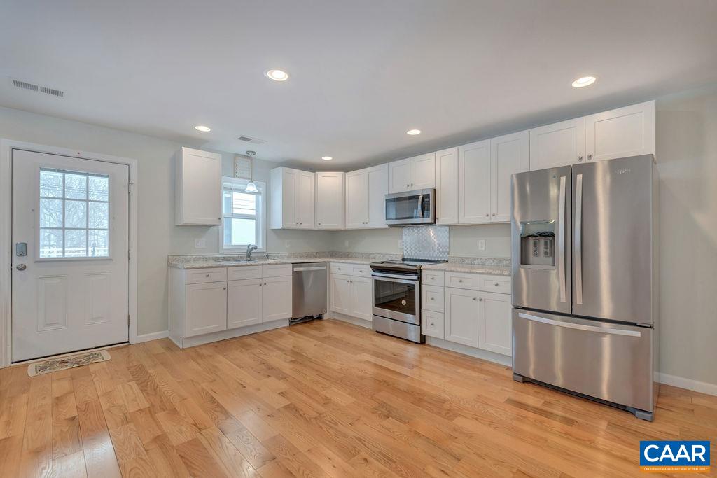 759 Mt Torrey Road Lyndhurst, VA 22952 - Photo 13 of 47 a kitchen with a refrigerator stainless steel appliances wooden floor and cabinets