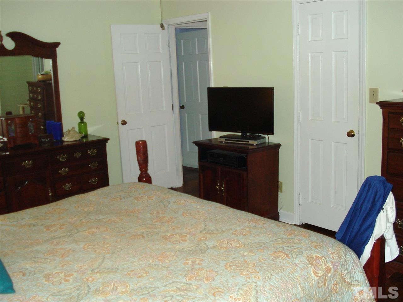 8712 Hidden View Court Raleigh, NC 27613 - Photo 11 of 17 a bedroom with a bed and a flat screen tv