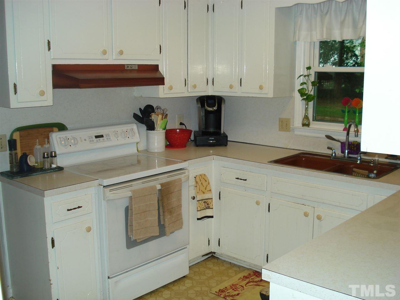 8712 Hidden View Court Raleigh, NC 27613 - Photo 7 of 17 a kitchen with white cabinets and white appliances