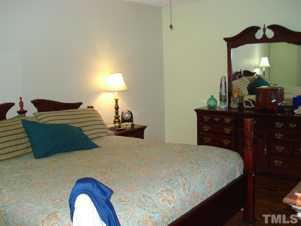 8712 Hidden View Court Raleigh, NC 27613 - Photo 10 of 17 a bedroom with a bed and lamp on dresser